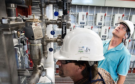 Senior Technician Bill Bray (front) and Master Technician Bob Lyons (back) inspect and service the biomass pretreatment reactor in NREL's Integrated Biorefinery Research Facility. Credit: Dennis Schroeder