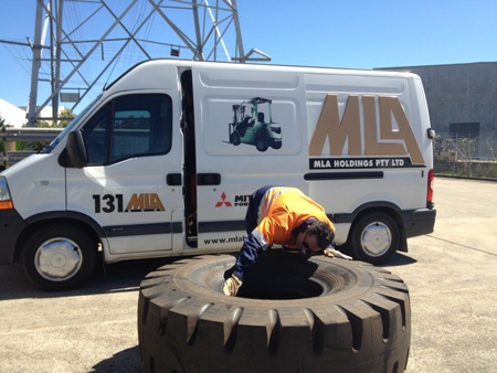 MLA technician inspecting a potentially dangerous 1800 x 25 tyre for any faults.