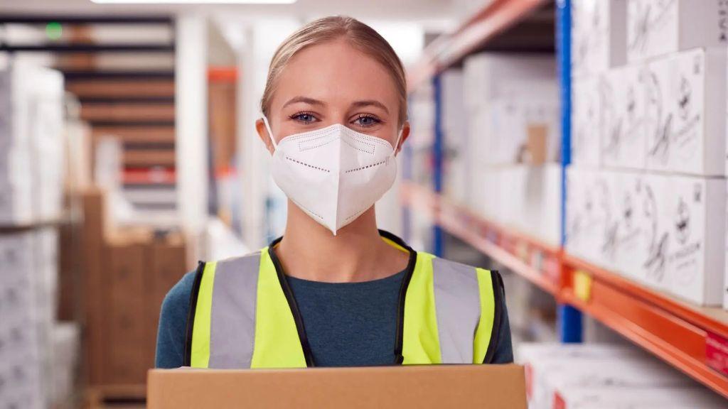 Woman holding PPE supplies in warehouse