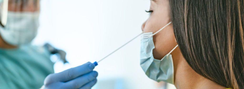 woman-undergoing-a-covid-antigen-nasal-swab-test-with-front-liner-in-full-ppe