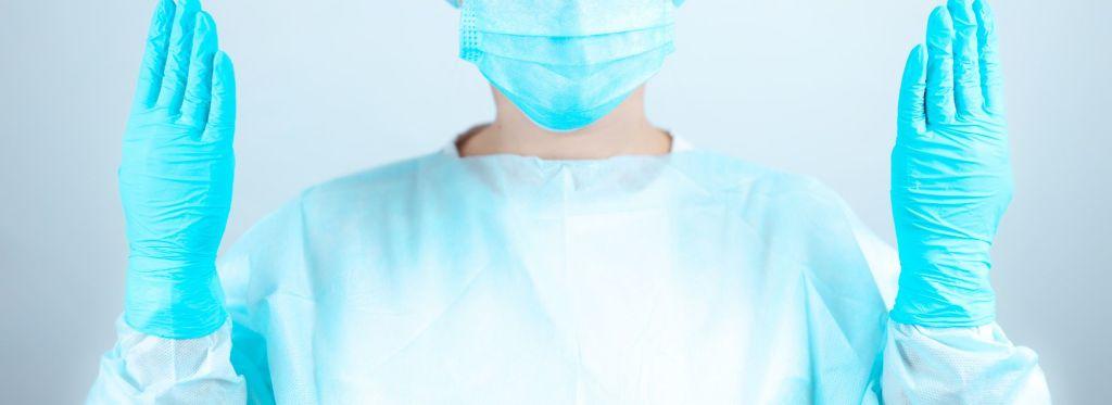 medical-worker-putting-on-sms-isolation-gown-and-full-ppe