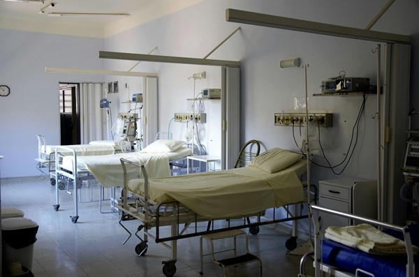 A clean hospital ward with adjustable beds, medical equipment, and curtain dividers, creating a safe and organized patient care environment.